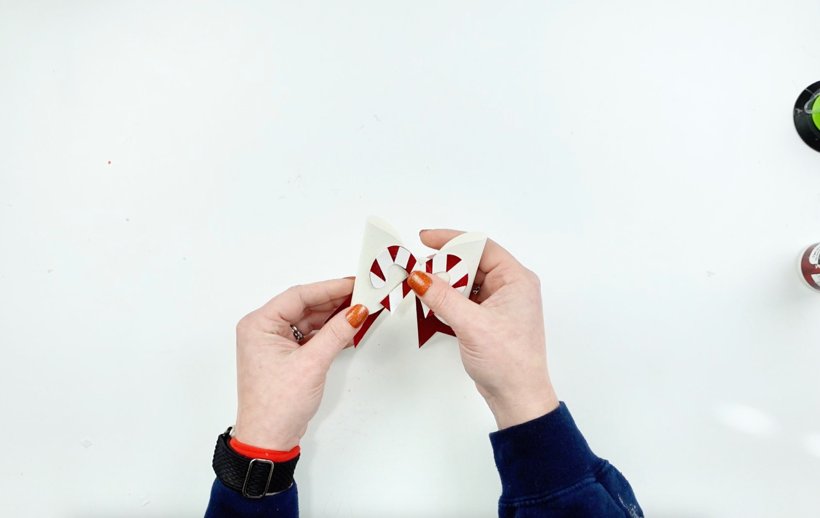 A DIY Bow made out of glitter cardstock in white and red. A DIY Christmas bow with a paper candy cane center. Easy beginner bow tutorial.